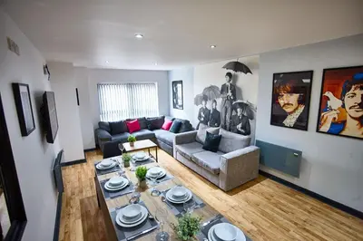 a living room with a table and a couch at STARR SUITE 6 Bedrooms, 6 Bathrooms in Liverpool