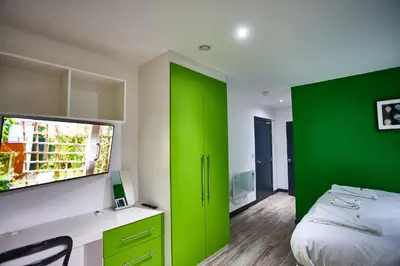 a green and white bedroom with a bed and a window at STARR SUITE 6 Bedrooms, 6 Bathrooms in Liverpool