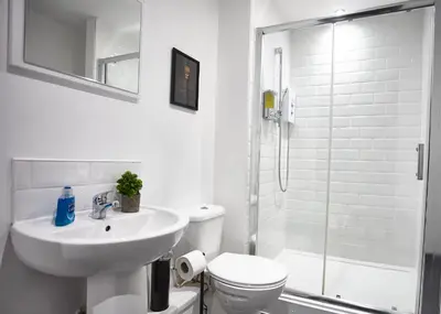 a white bathroom with a sink and a shower at STARR SUITE 6 Bedrooms, 6 Bathrooms in Liverpool