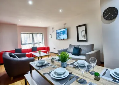 a living room with a table and a couch at LENNON SUITE 4 Bedrooms, 4 Bathrooms in Liverpool