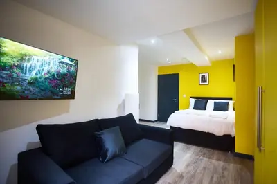 a living room with a couch and a bed at LENNON SUITE 4 Bedrooms, 4 Bathrooms in Liverpool