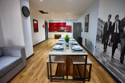 a dining table with plates on it in a living room at LENNON SUITE 4 Bedrooms, 4 Bathrooms in Liverpool