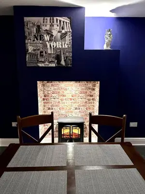 a living room with a fireplace with two chairs and a table at Beautiful Entire House! in Liverpool