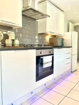 a kitchen with white cabinets and an oven at Beautiful Entire House! in Liverpool