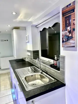 a kitchen with a sink and a large mirror at Beautiful Entire House! in Liverpool