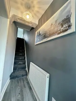 a hallway with stairs and a chandelier and pictures on the wall at Beautiful Entire House! in Liverpool