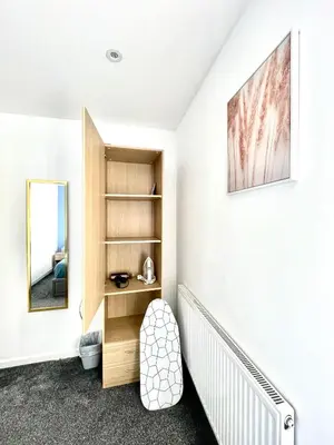 a bedroom with white walls and a staircase with a mirror at Beautiful Entire House! in Liverpool