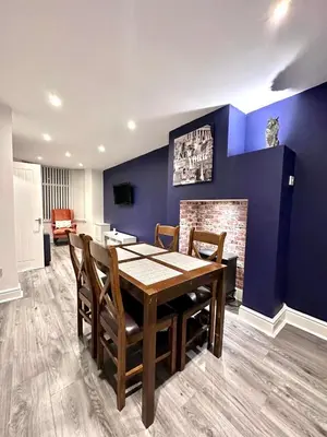 a dining room with a table and a fireplace at Beautiful Entire House! in Liverpool