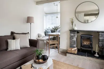 a living room with a couch and a fireplace at Drakes Cottage in Cartmel