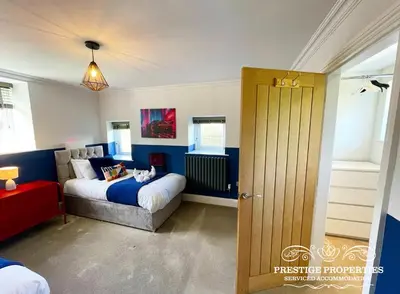 a bedroom with a bed and a couch in it at Millstream Barn by Prestige Properties SA in Millom