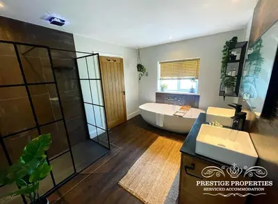 a bathroom with a tub and a sink and a shower at Millstream Barn by Prestige Properties SA in Millom