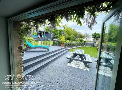 a view of a deck with a bench and a swing at Millstream Barn by Prestige Properties SA in Millom