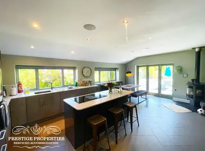 a kitchen with a large island in the middle at Millstream Barn by Prestige Properties SA in Millom