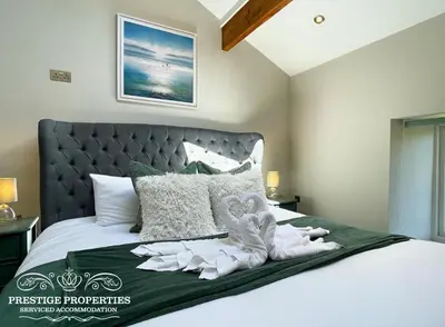 a bedroom with a bed with towels on it at Millstream Barn by Prestige Properties SA in Millom