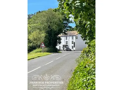 a street with a white house and a road at Millstream Barn by Prestige Properties SA in Millom