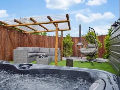 a backyard with a hot tub and a pergola at Laurel Pod - Uk47203 in Westhead