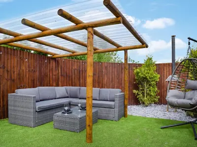 a pergola in a backyard with two couches and a table at Laurel Pod - Uk47203 in Westhead