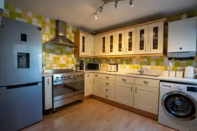 a kitchen with a refrigerator and a washer in it at Spacious Town House in Lytham St Annes