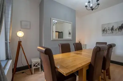 a dining room with a wooden table and chairs at Spacious Town House in Lytham St Annes