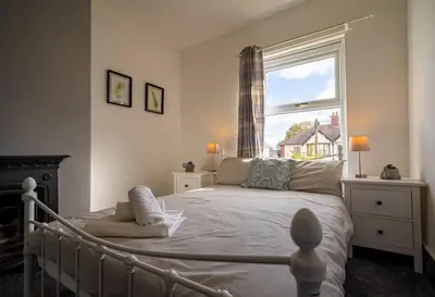 a bedroom with a large bed and a window at Spacious Town House in Lytham St Annes