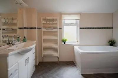 a white bathroom with a tub and a sink at Spacious Town House in Lytham St Annes