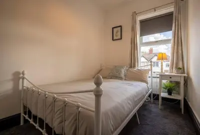 a bedroom with a bed with a window and a bed frame at Spacious Town House in Lytham St Annes