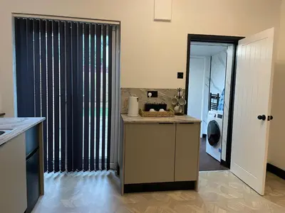 a kitchen with a counter and a washer and dryer at Slick Space for a Standish Stay in Standish