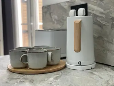 a group of coffee cups on a counter next to a juicer at Slick Space for a Standish Stay in Standish