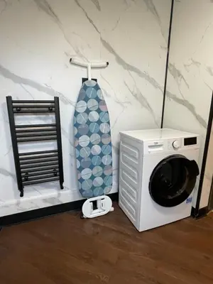 a microwave and a washing machine in a room at Slick Space for a Standish Stay in Standish