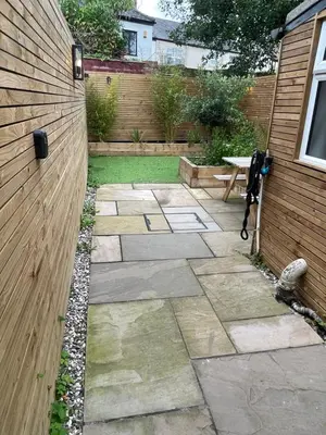 a backyard with a stone patio and a fence at Slick Space for a Standish Stay in Standish