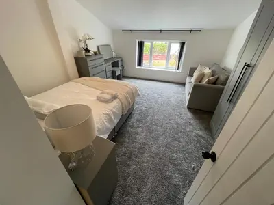 a bedroom with a bed and a couch and a window at Slick Space for a Standish Stay in Standish