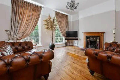 a living room with two leather couches and a fireplace at City Centre Georgian Listed Townhouse in Liverpool