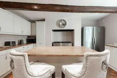 a kitchen with a large wooden table with two chairs at City Centre Georgian Listed Townhouse in Liverpool