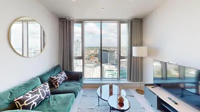 a living room with a green couch and a large window at Charles Hope Liverpool in Liverpool