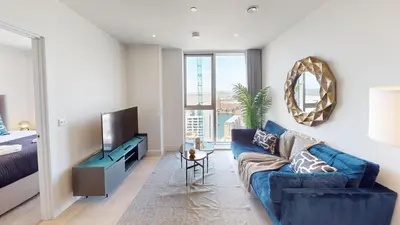 a living room with a blue couch and a television at Charles Hope Liverpool in Liverpool