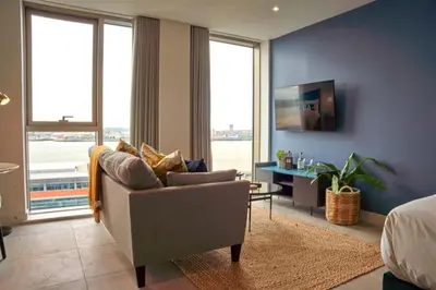 a living room with a couch and a table and windows at Charles Hope Liverpool in Liverpool