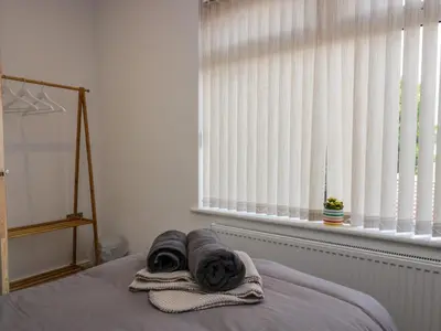 a bed with towels on it in a room with a window at Brynmar in Morecambe