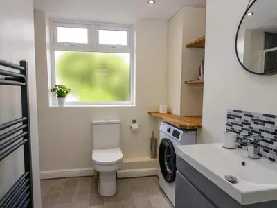 a bathroom with a toilet and a sink and a window at Brynmar in Morecambe