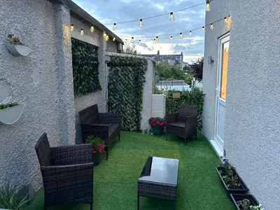 an outdoor patio with chairs and a table and a fence at Brynmar in Morecambe