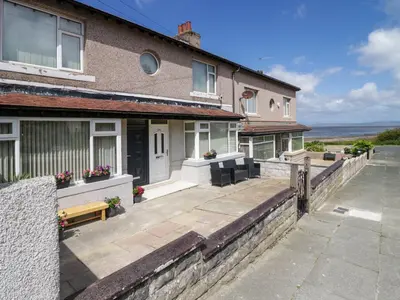 a house with a patio and a view of the ocean at Brynmar in Morecambe
