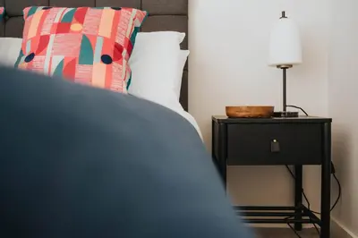 a bed with a side table with a lamp on it at Chavasse Apartments, 1 Bed Studio, Parking - Pass the Keys in Liverpool