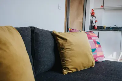 a blue couch with two pillows on it at Chavasse Apartments, 1 Bed Studio, Parking - Pass the Keys in Liverpool