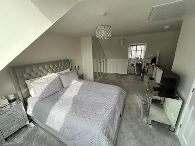 a bedroom with a bed and a desk and a television at Drey Close in Formby