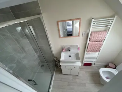 a bathroom with a shower and a sink and a mirror at Drey Close in Formby