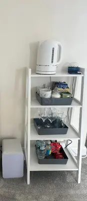 a white shelf with a microwave on top of it at Drey Close in Formby