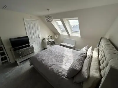 a bedroom with a bed and a flat screen tv at Drey Close in Formby