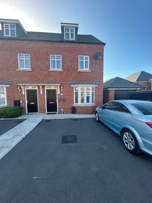 a blue car parked in front of a brick house at Drey Close in Formby