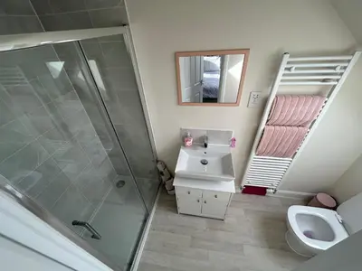 a bathroom with a shower and a sink and a toilet at Drey Close in Formby