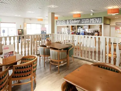 a restaurant with wooden tables and chairs and a counter at Sea Breeze in Heysham