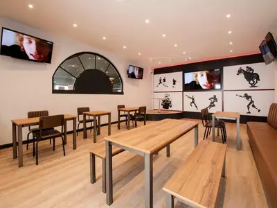 a dining room with tables and chairs and televisions at Sea Breeze in Heysham
